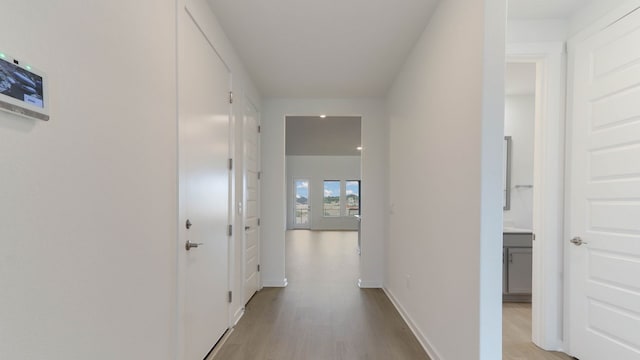 hallway with light hardwood / wood-style floors