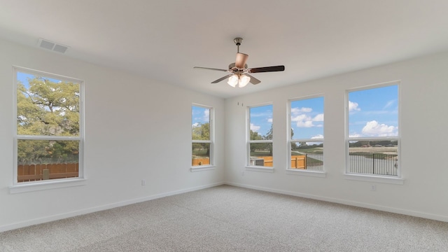 carpeted empty room featuring ceiling fan and a healthy amount of sunlight