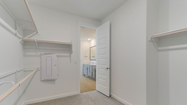 walk in closet featuring light carpet