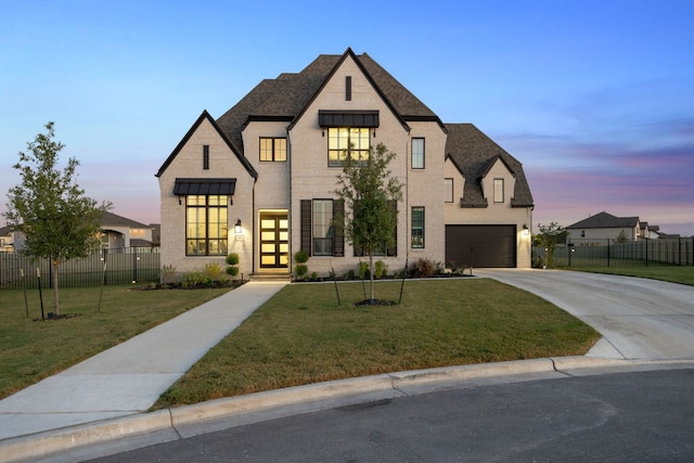 french country inspired facade with a lawn and a garage