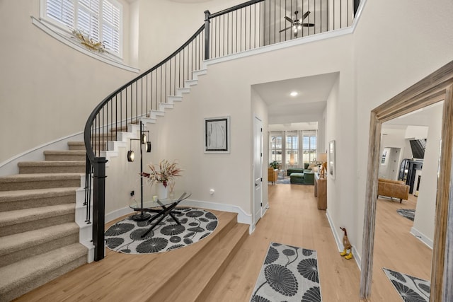 entryway featuring a high ceiling, light hardwood / wood-style flooring, and ceiling fan