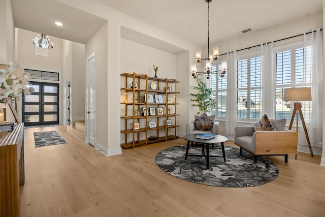 sitting room with a notable chandelier, light wood-type flooring, and plenty of natural light