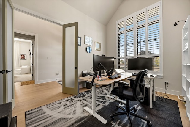 home office featuring vaulted ceiling and light hardwood / wood-style flooring