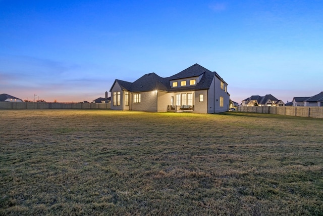 property exterior at dusk with a lawn