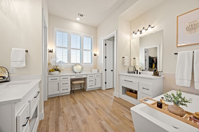 bathroom with vanity, a bathtub, and hardwood / wood-style flooring