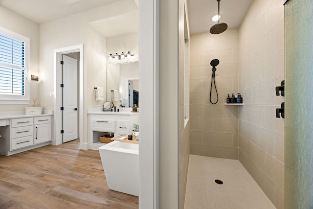 bathroom featuring vanity, hardwood / wood-style flooring, and tiled shower