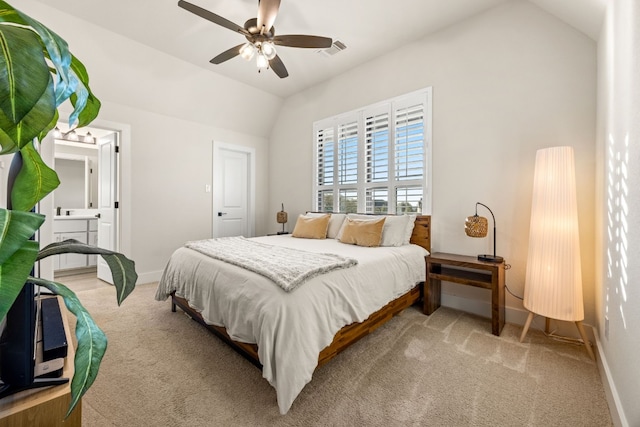 bedroom with connected bathroom, vaulted ceiling, carpet floors, and ceiling fan