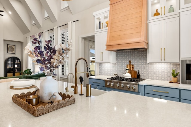 kitchen with decorative backsplash, white cabinets, lofted ceiling with beams, and blue cabinetry