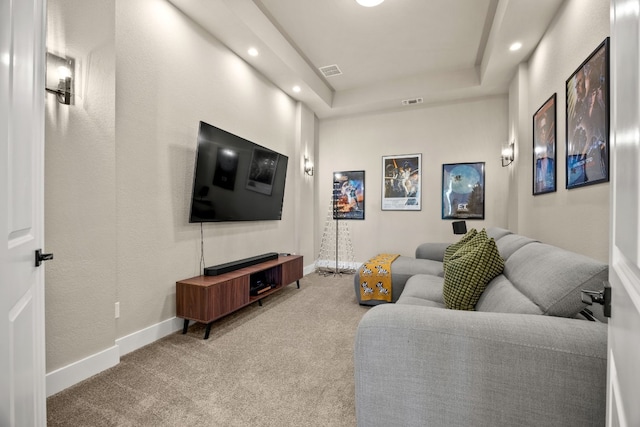 living room with carpet floors and a tray ceiling