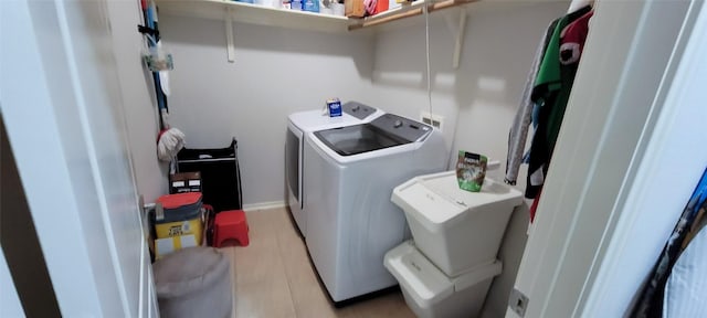 laundry room with light wood-type flooring and separate washer and dryer