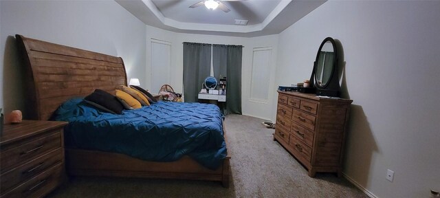 bedroom featuring carpet floors, a tray ceiling, and ceiling fan