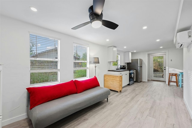 living room featuring recessed lighting, an AC wall unit, and light wood-style flooring