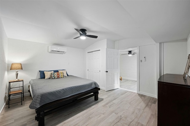 bedroom featuring light wood-type flooring, a ceiling fan, vaulted ceiling, and an AC wall unit