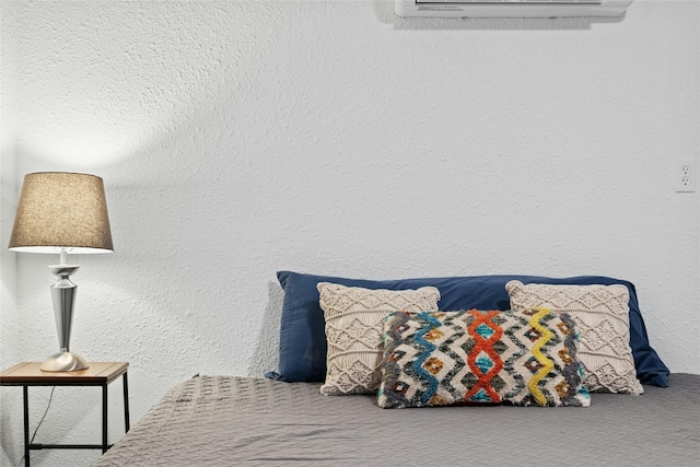 carpeted bedroom featuring a textured wall and a wall mounted air conditioner