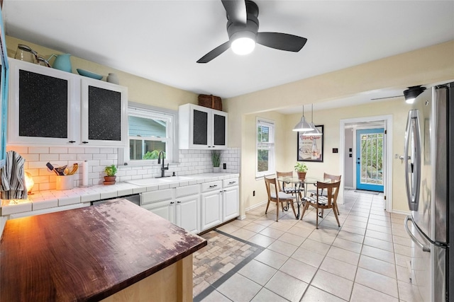 kitchen with a sink, stainless steel appliances, backsplash, and a wealth of natural light