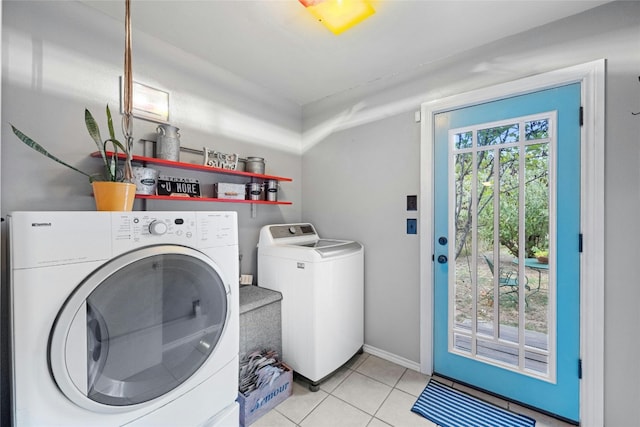 laundry room featuring laundry area, baseboards, light tile patterned flooring, and independent washer and dryer