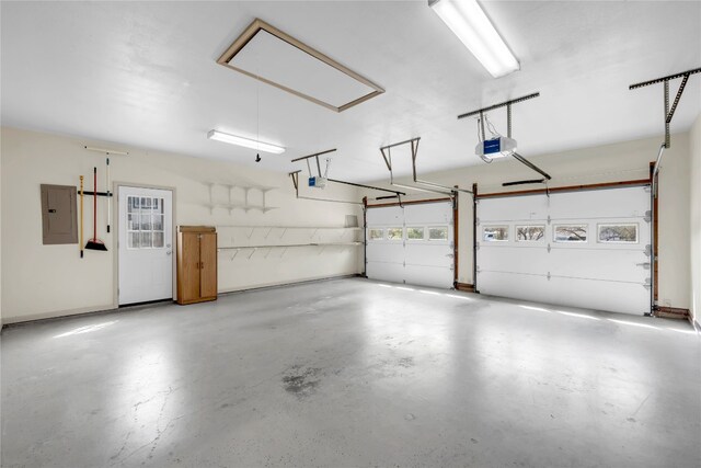 garage with a garage door opener and electric panel