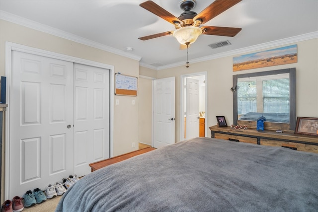 carpeted bedroom with crown molding, a closet, and ceiling fan