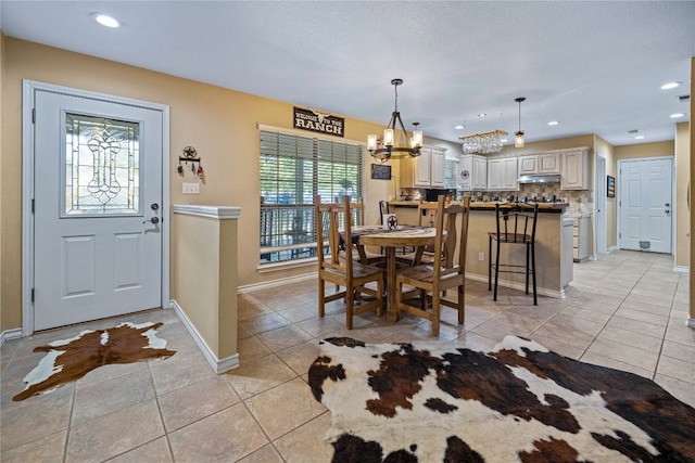 tiled dining room with a notable chandelier