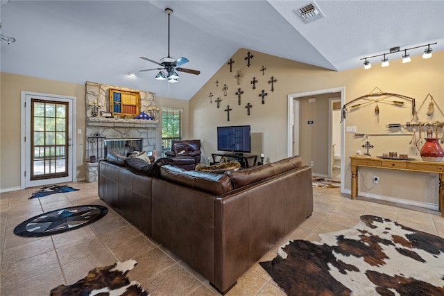 living room with light tile patterned floors, a stone fireplace, high vaulted ceiling, and ceiling fan