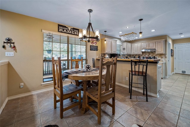 dining space with a chandelier and tile patterned flooring