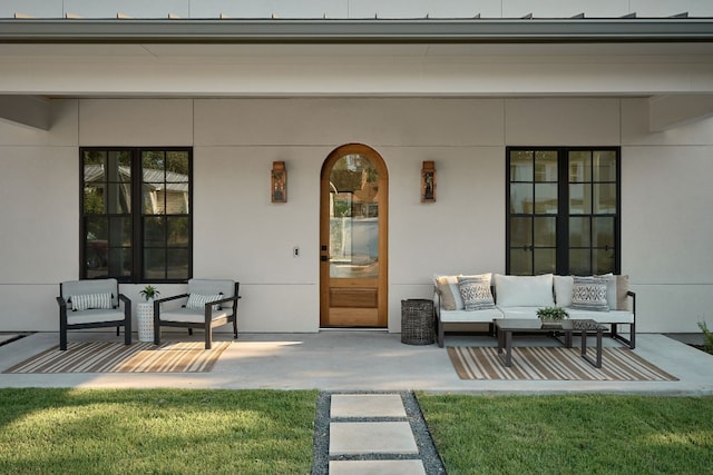 property entrance with outdoor lounge area, a yard, and a patio area