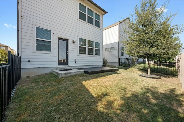 back of house with a patio and a lawn