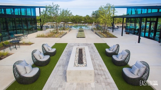 view of home's community with a pool, a patio, and a fire pit