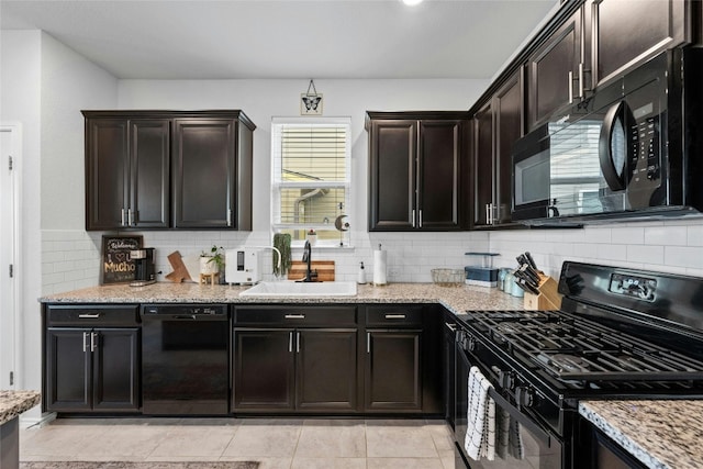 kitchen with dark brown cabinetry, light stone counters, black appliances, and sink