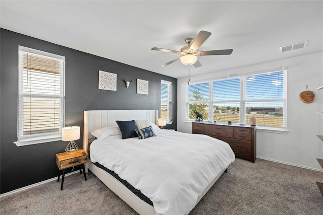 carpeted bedroom with multiple windows and ceiling fan