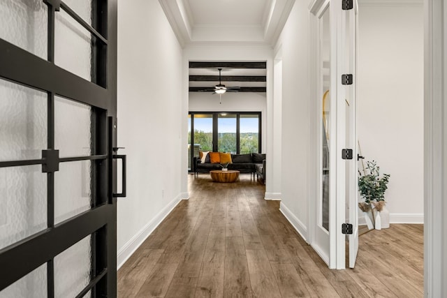 hallway featuring beamed ceiling, coffered ceiling, light hardwood / wood-style flooring, and ornamental molding