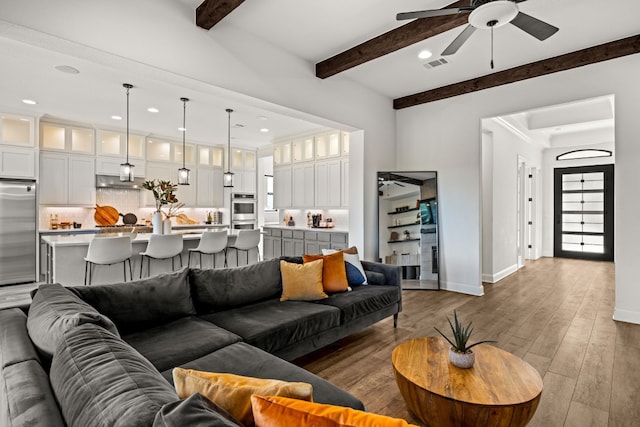 living room with hardwood / wood-style flooring, beamed ceiling, and ceiling fan