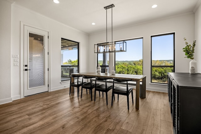 dining area featuring crown molding, hardwood / wood-style flooring, and a notable chandelier