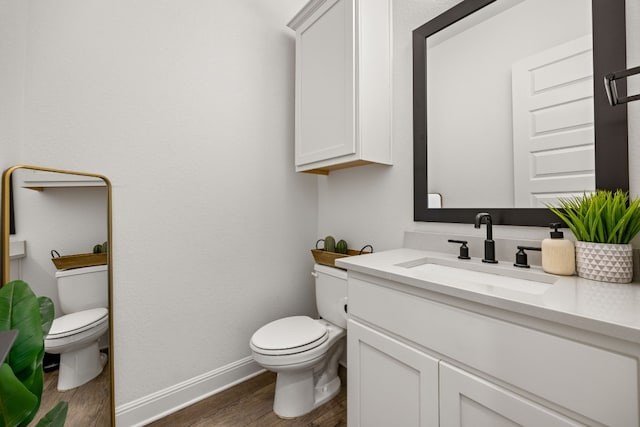 bathroom featuring vanity, toilet, and hardwood / wood-style floors