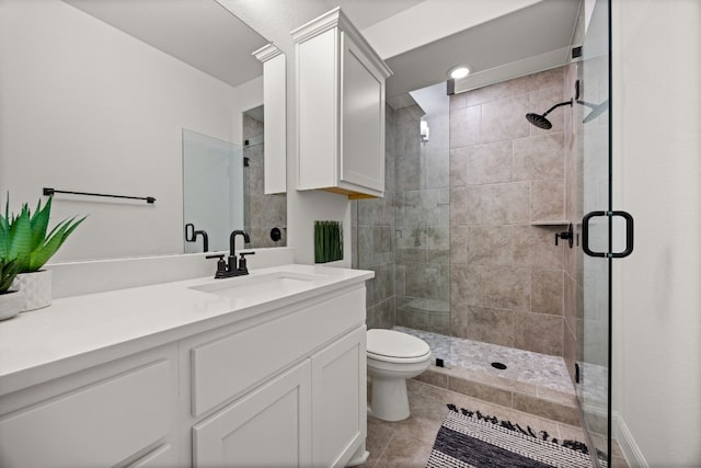 bathroom with vanity, tile patterned floors, toilet, and an enclosed shower