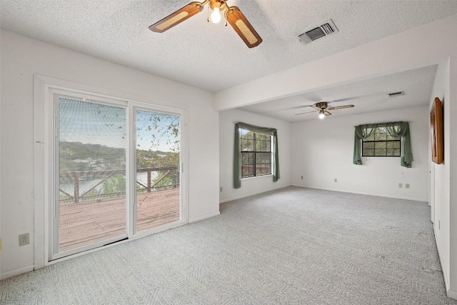 502 E Ave, Marble Falls, TX 78654 - carpeted spare room featuring a ceiling fan, healthy amount of natural light, a textured ceiling, and baseboards