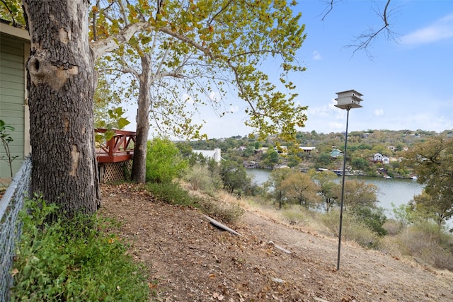 view of yard with a deck with water view