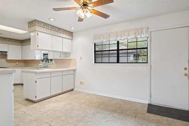 kitchen with extractor fan, sink, white cabinets, a textured ceiling, and ceiling fan