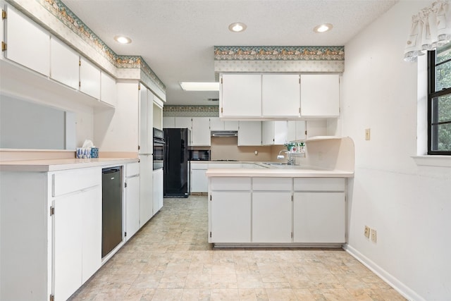 kitchen featuring kitchen peninsula, white cabinetry, a textured ceiling, black appliances, and sink