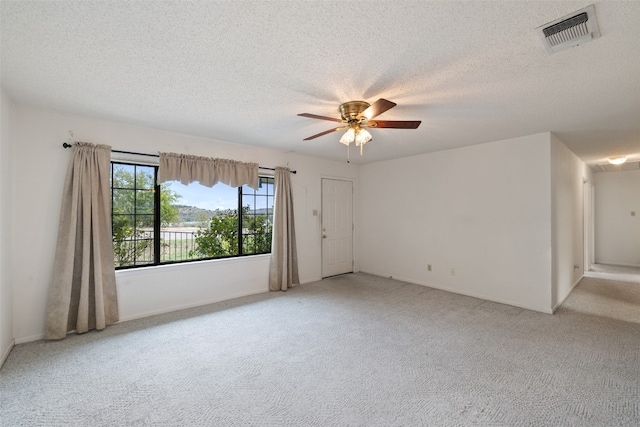 empty room featuring carpet, a textured ceiling, and ceiling fan