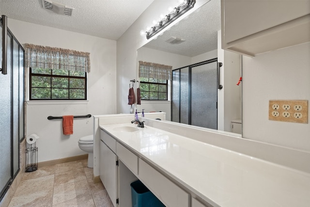 bathroom with vanity, a textured ceiling, toilet, and walk in shower