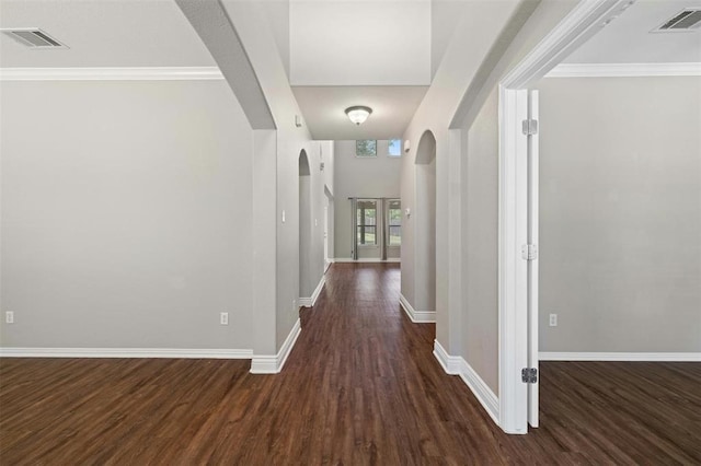 hall with dark wood-type flooring and crown molding