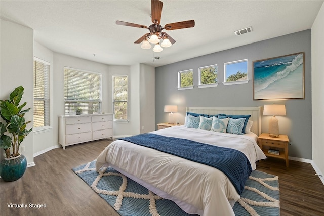 bedroom featuring a textured ceiling, wood-type flooring, and ceiling fan