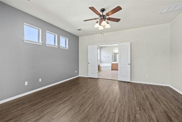 interior space with ensuite bath, hardwood / wood-style flooring, and ceiling fan