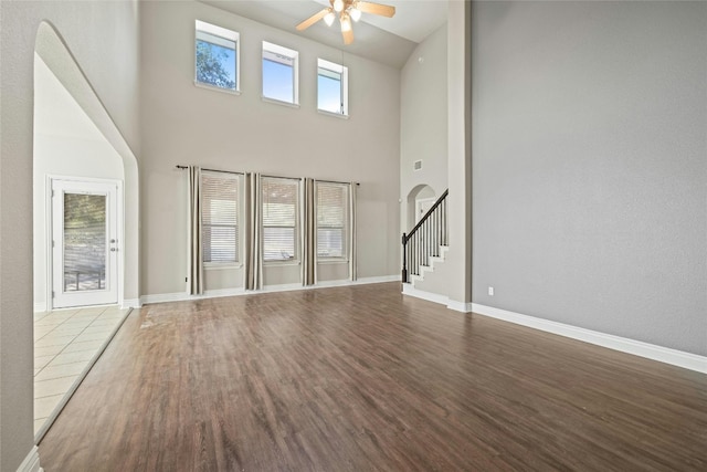 unfurnished living room featuring hardwood / wood-style floors, high vaulted ceiling, and ceiling fan