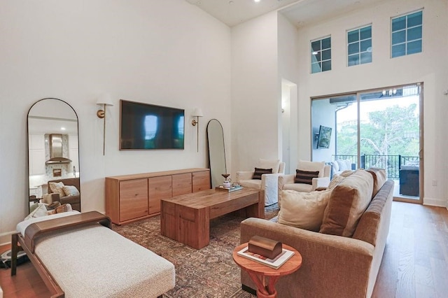 living room with dark hardwood / wood-style floors and a towering ceiling