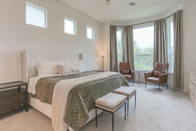 bedroom featuring light carpet and multiple windows