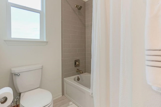 bathroom featuring toilet, hardwood / wood-style floors, and shower / tub combo