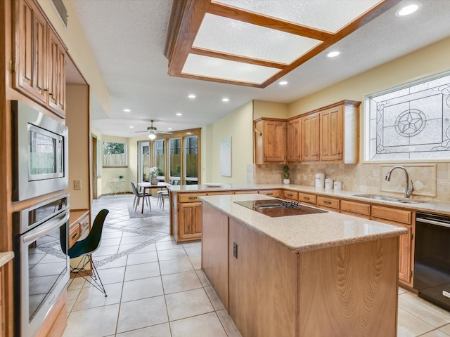 kitchen with sink, a center island, kitchen peninsula, decorative backsplash, and black appliances