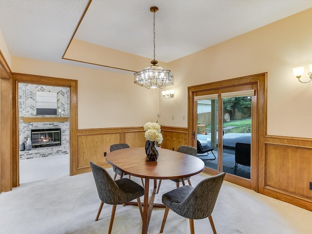 carpeted dining room with a brick fireplace